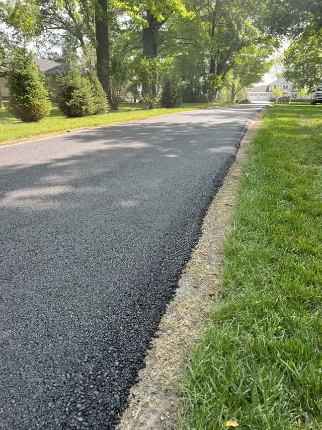 Clean compacted asphalt edge meeting a green lawn