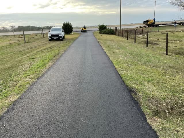 Long rural driveway with fresh asphalt surface