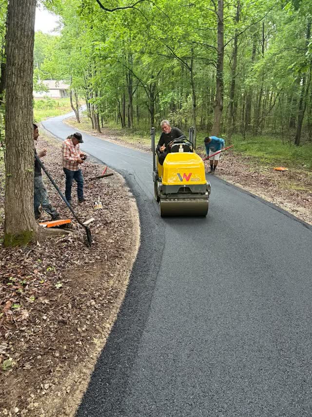 Crew with walk-behind roller on a wooded path