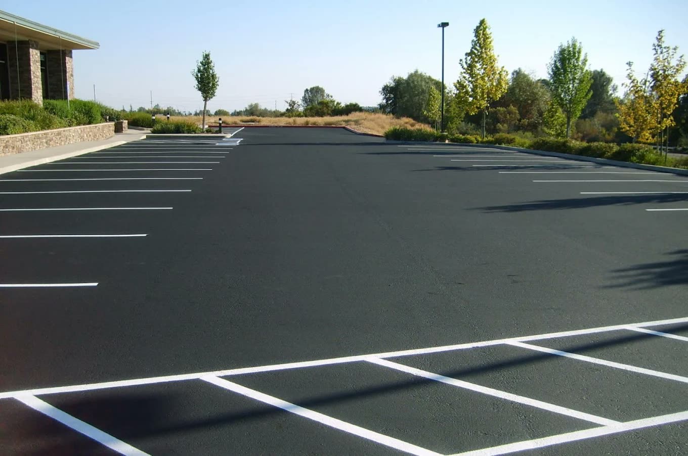 Deep black parking lot finished with fresh white line striping