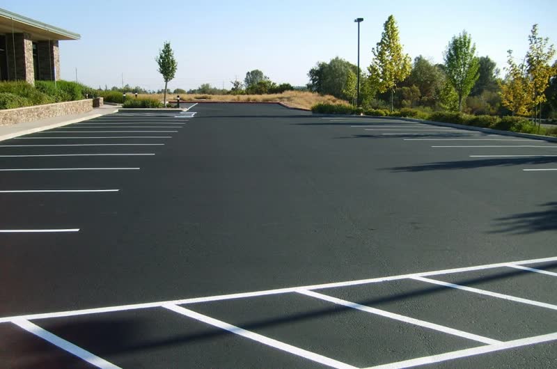 Deep black parking lot finished with fresh white line striping