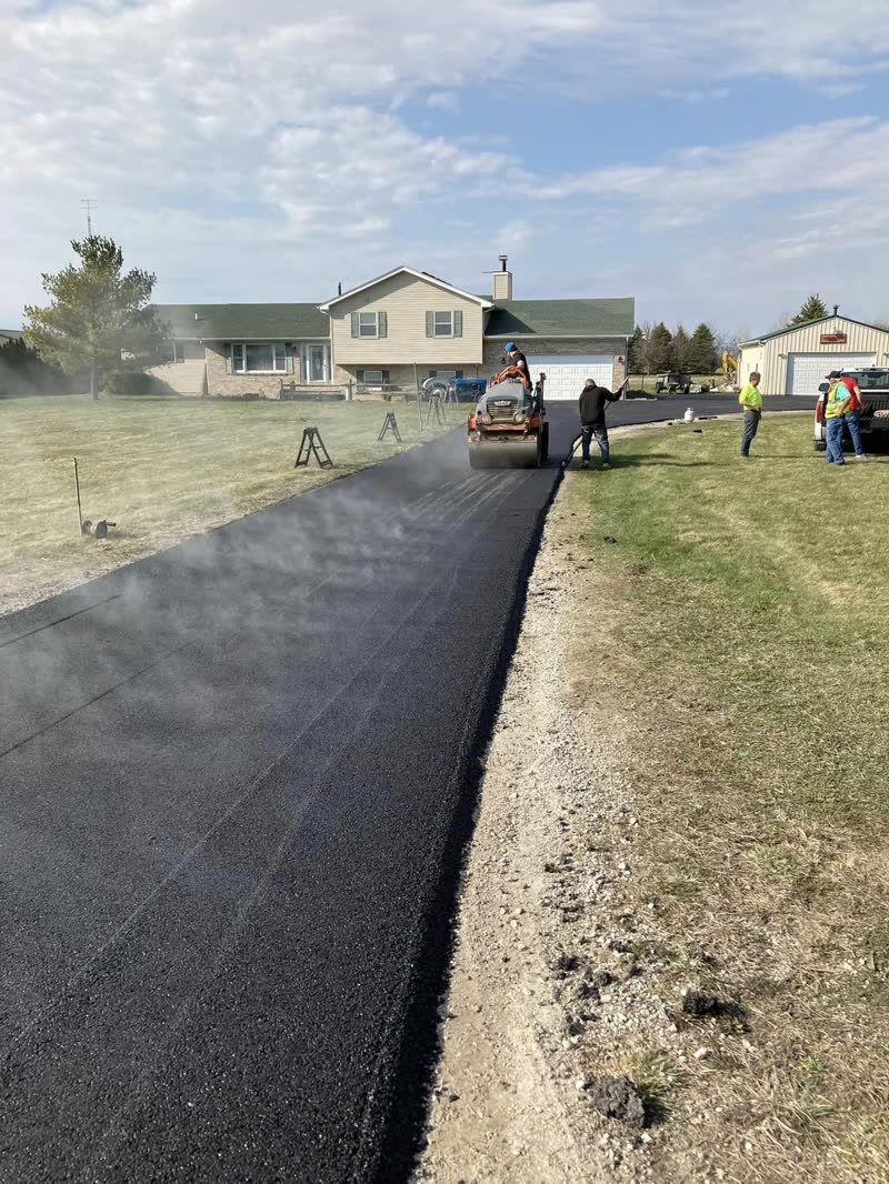 Cornell's crew rolling fresh hot-mix asphalt on a residential driveway
