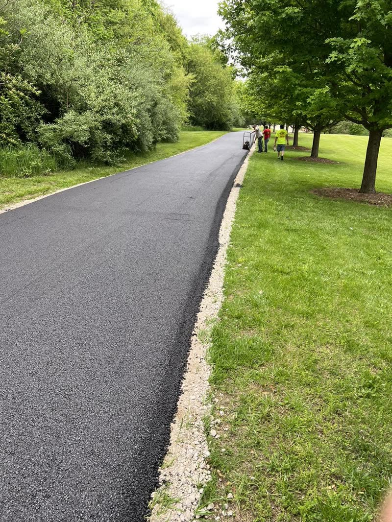 Long freshly compacted recycled-asphalt drive with the crew at the far end