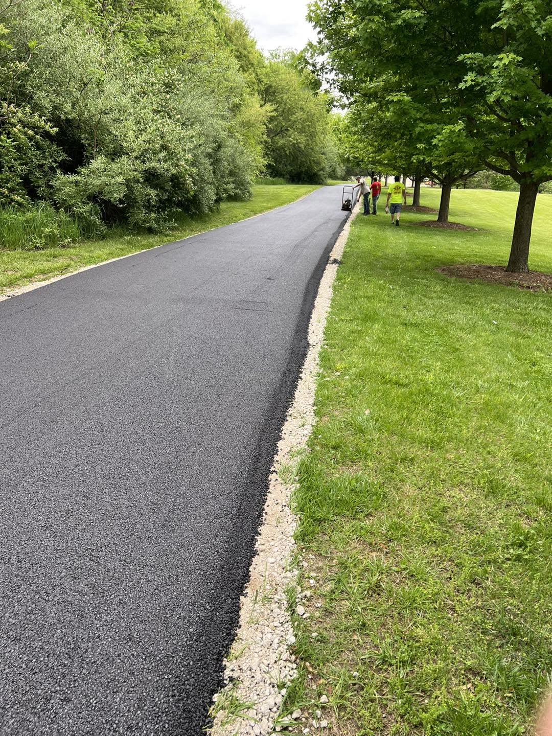 Long freshly compacted recycled-asphalt drive with the crew at the far end
